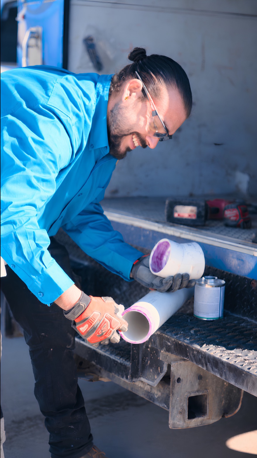 Elite Rooter technician priming PVC pipe at the service truck