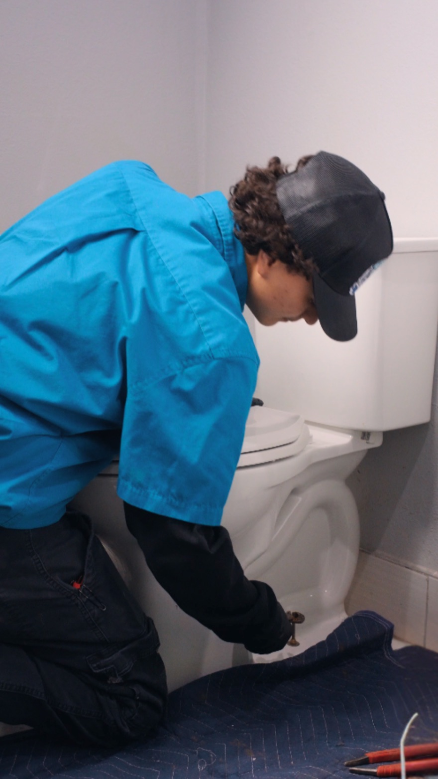 Elite Rooter technician inspecting the base of a toilet