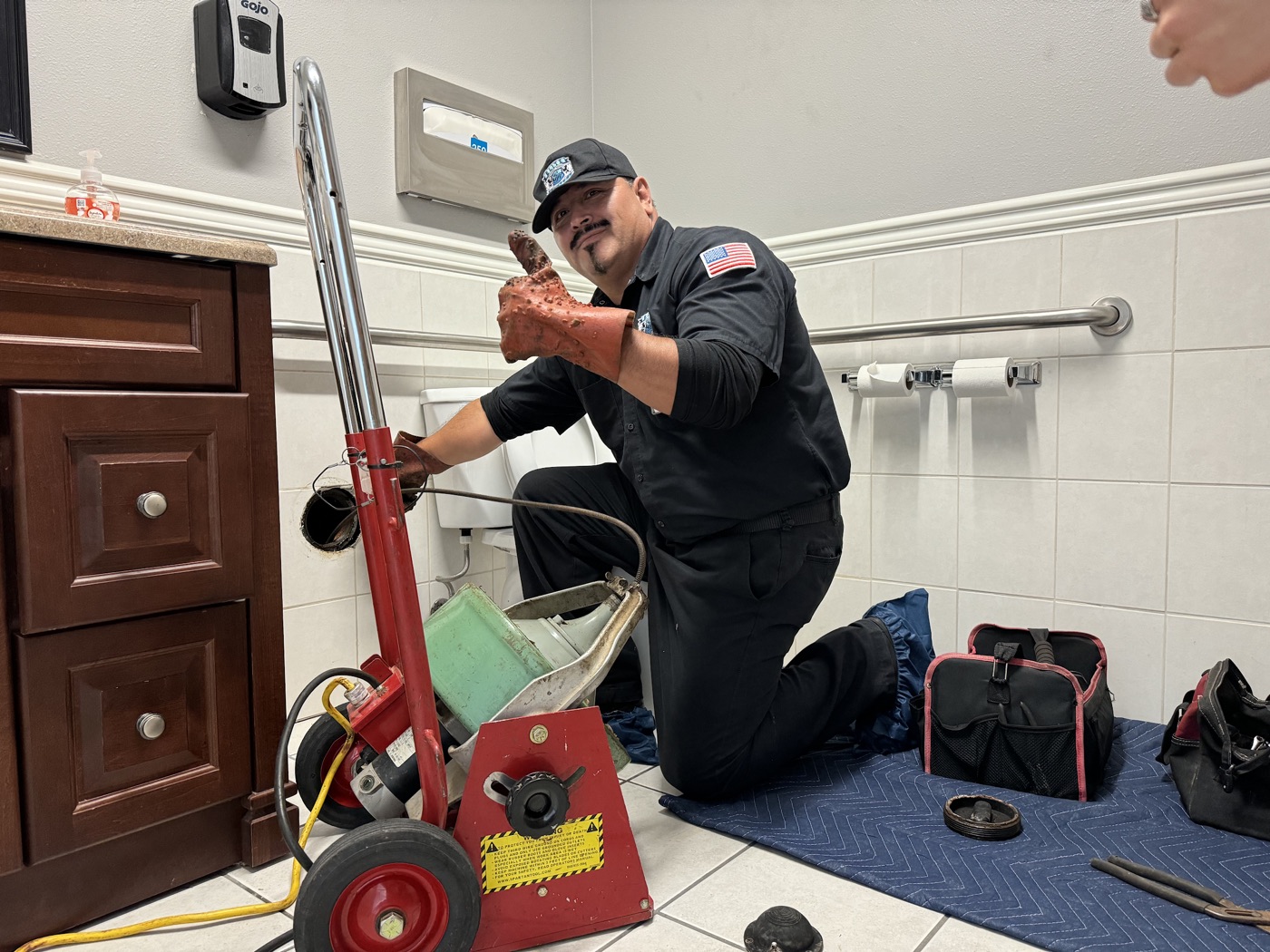 Elite Rooter technician clearing a drain with a cable machine