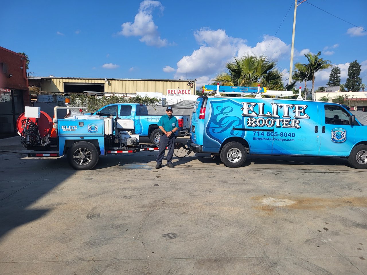 Elite Rooter technician with service vehicles and drain cleaning equipment