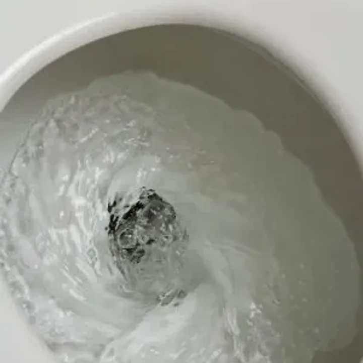 Water swirling in a residential toilet bowl