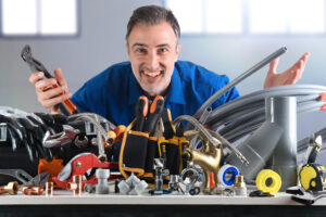 Plumbing material and smiling plumber behind in industrial warehouse