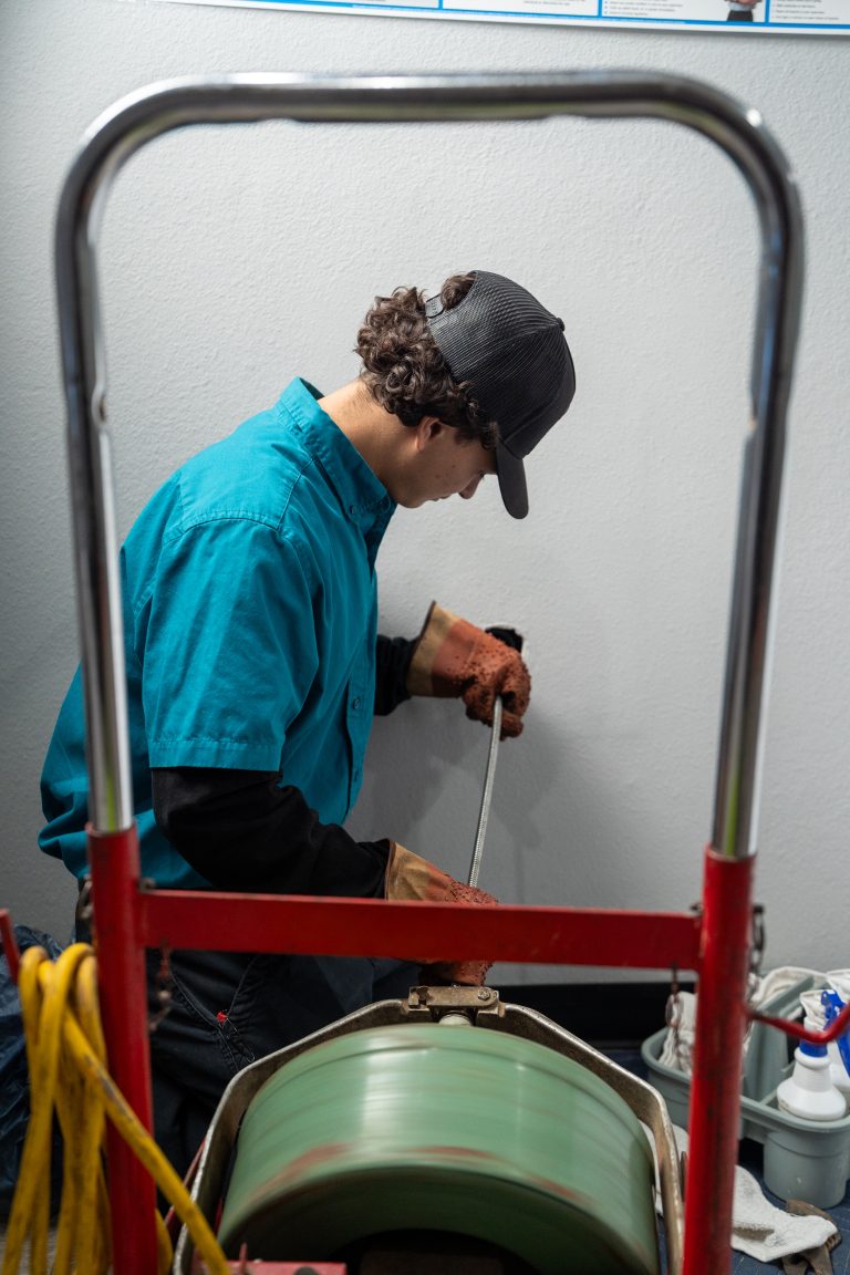 Elite Rooter drain cleaning technician working with professional equipment